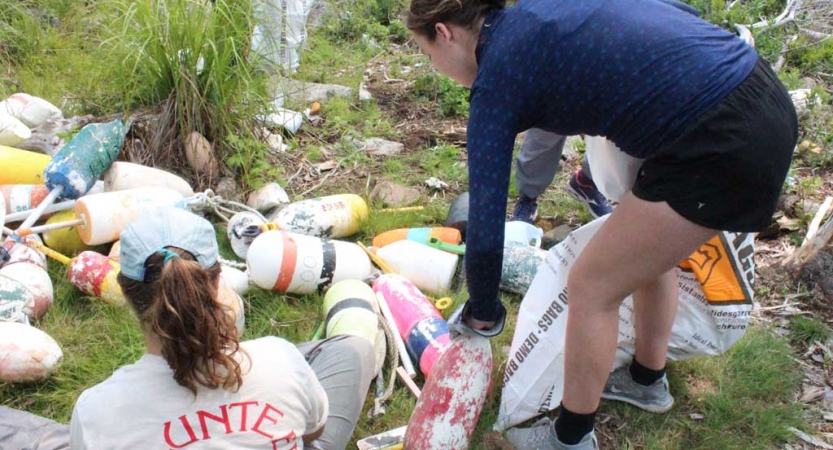 Two people sort through trash as part of a service project